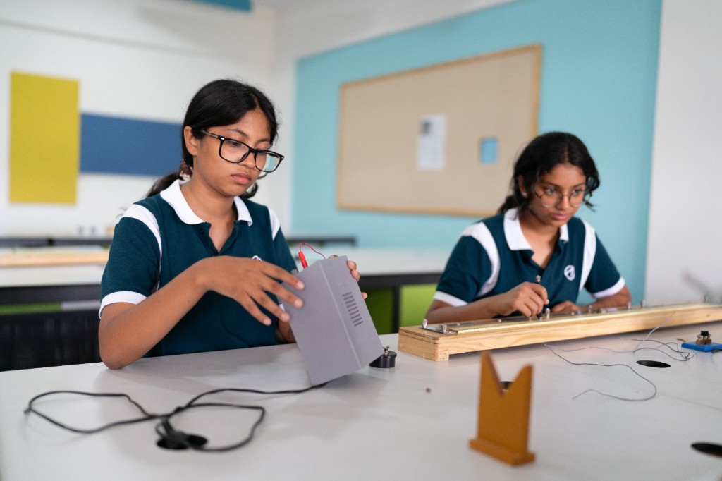 Students conducting a physics experiment in the science lab at TACS