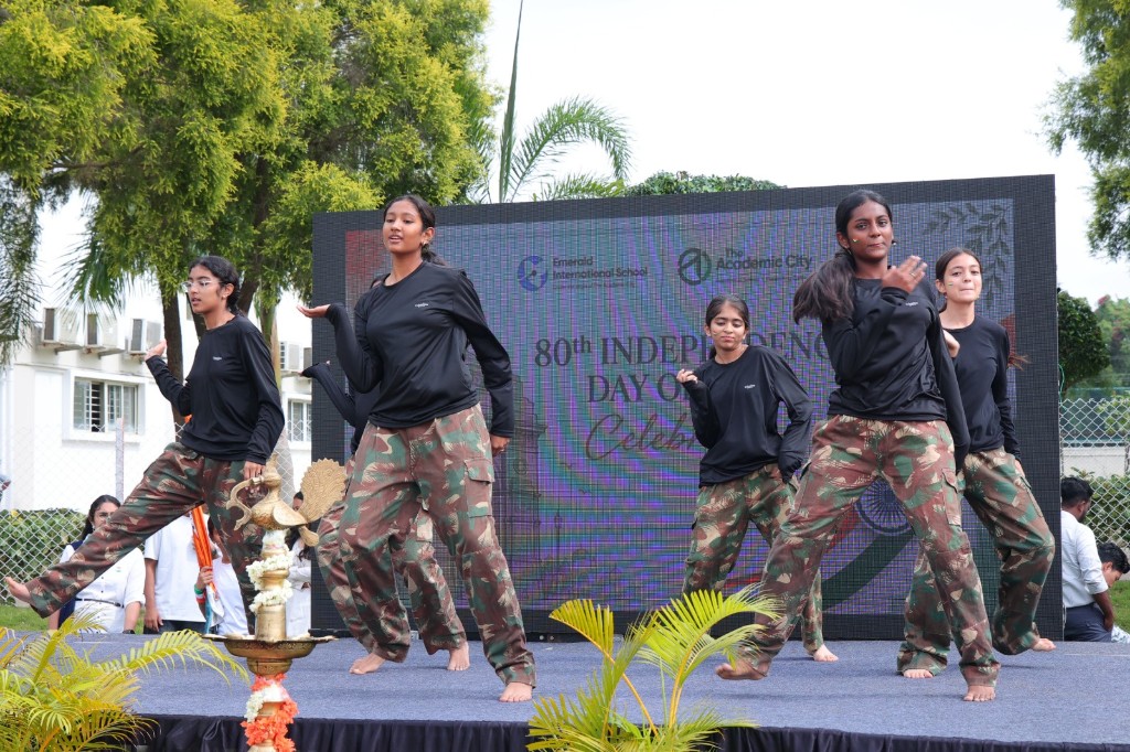 Students performing a choreographed dance on stage at TACS