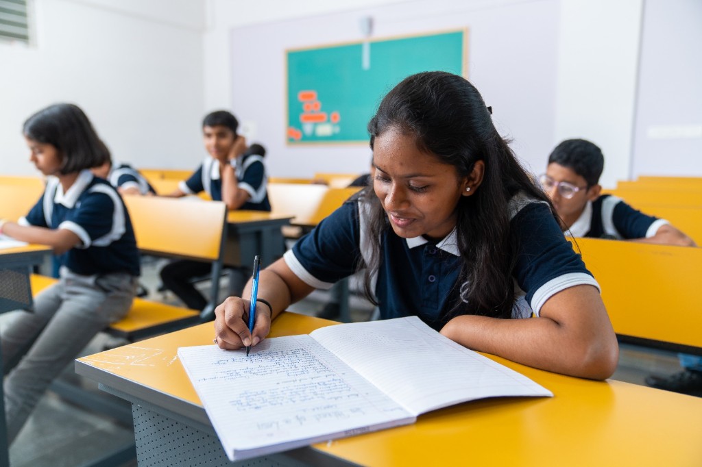 Student taking notes during classroom learning at TACS