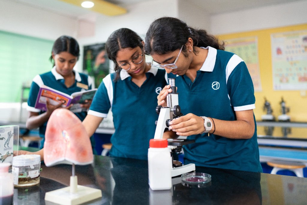 Students using a microscope in the science lab at TACS