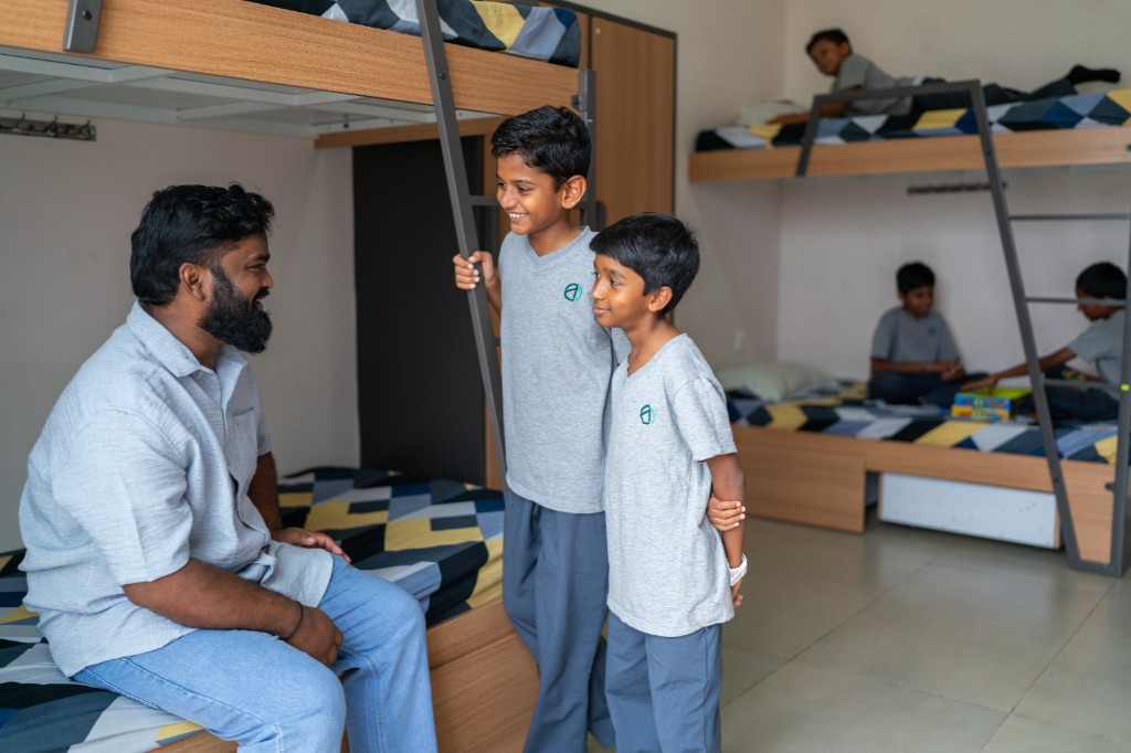 Dorm parent interacting with students in the hostel at TACS