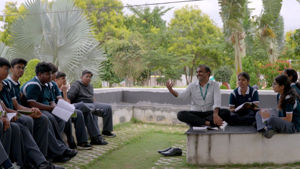 Teacher leading an outdoor learning session on campus at TACS