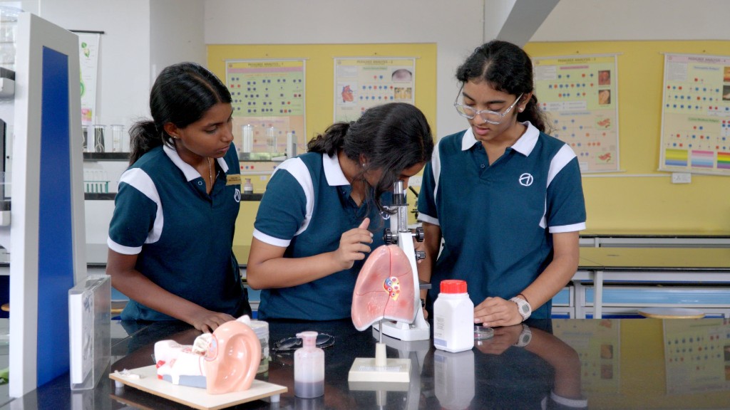 Students using a microscope in the campus science lab at TACS