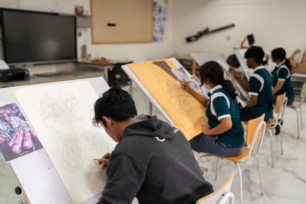 Students practising portrait drawing in the fine arts studio at TACS