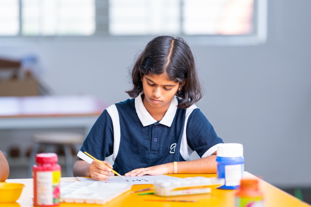 Student painting during an art session at TACS